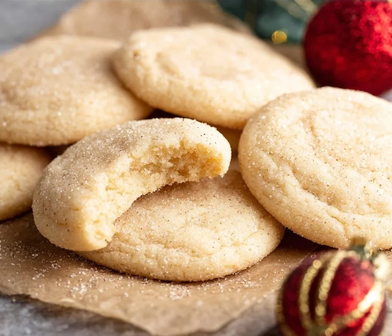 Batch of chewy sugar cookies on a baking tray, fresh out of the oven.