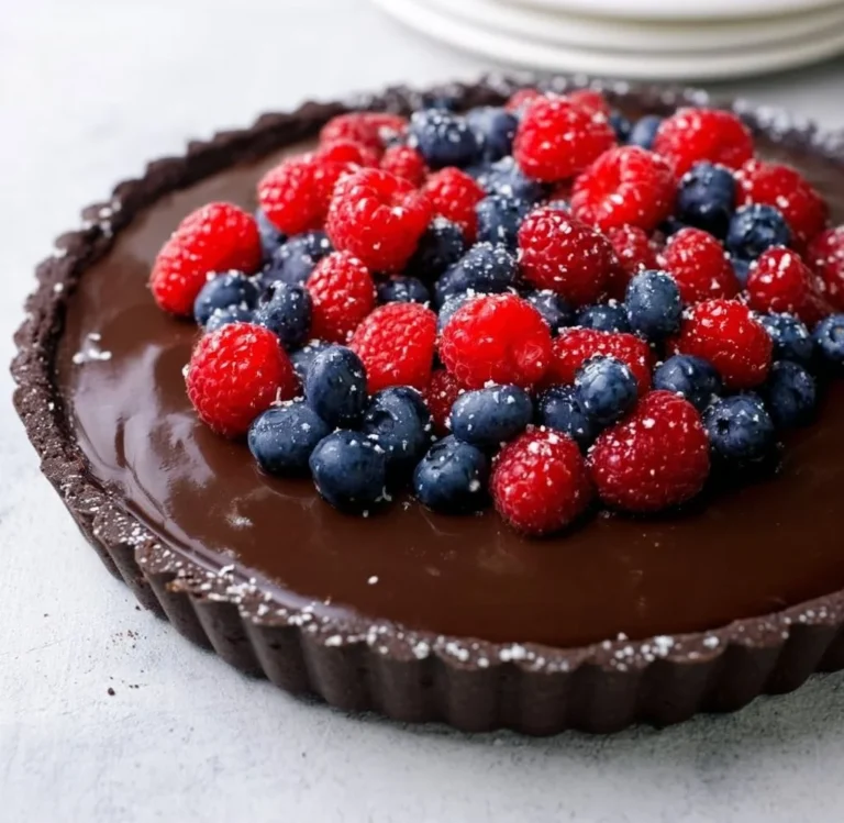 No bake dark chocolate tart topped with fresh berries and whipped cream
