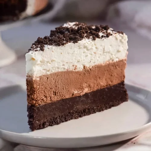 Delicious Oreo Mousse Cake topped with crushed Oreos and whipped cream
