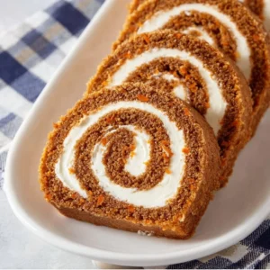 Delicious carrot cake roll topped with cream cheese frosting and garnished with cinnamon.