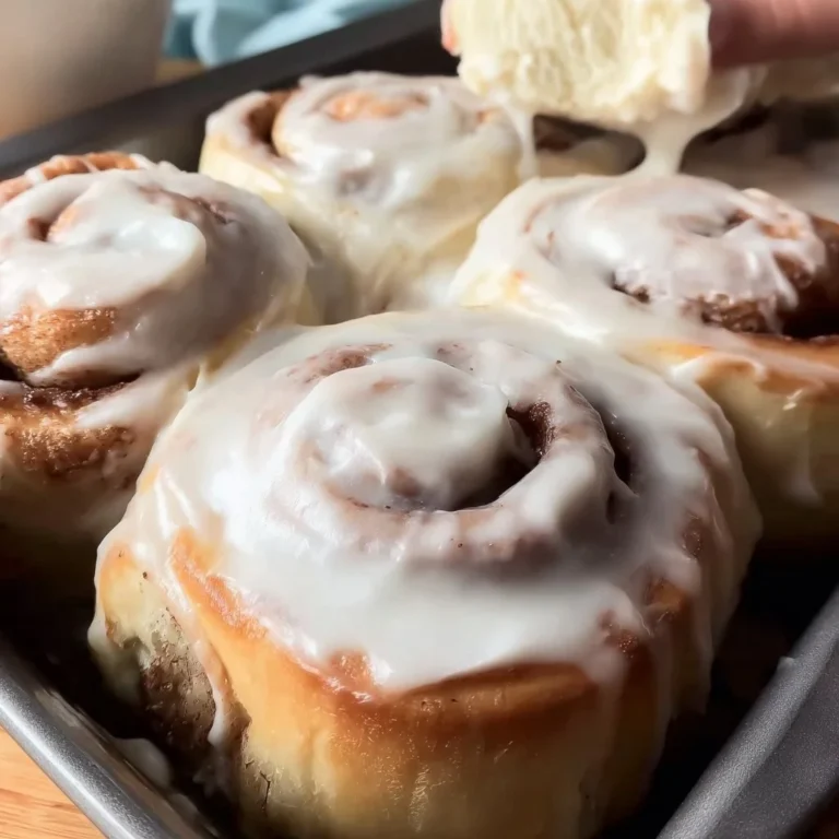 Delicious homemade cinnamon rolls with icing and cinnamon on a plate