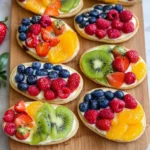 Colorful fruit pizzas topped with fresh fruits and creamy frosting.