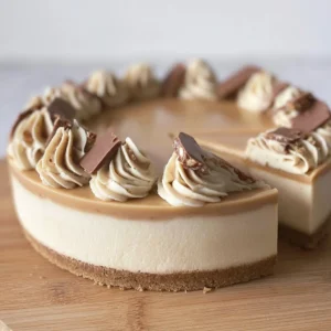 Delicious no-bake Kinder Bueno cheesecake topped with chocolate and hazelnuts.